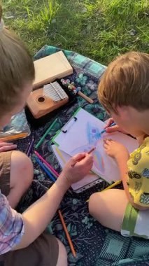 Dikey genç baba ve oğul yaz pikniğinin tadını çıkarıyor, birlikte güzel vakit geçiriyorlar. Dışarıdaki eğlenceli aktivitelere katılıyorlar, sıcak güneşin altında mutlu anılar yaratıyorlar.