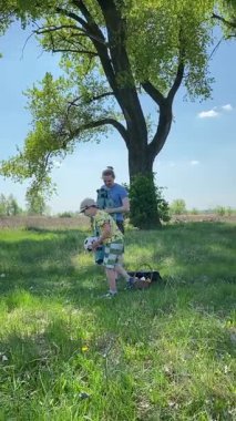 Dikey genç baba ve oğul yaz pikniğinin tadını çıkarıyor, birlikte güzel vakit geçiriyorlar. Dışarıdaki eğlenceli aktivitelere katılıyorlar, sıcak güneşin altında mutlu anılar yaratıyorlar.