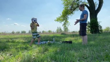 Küçük baba ve oğlu yaz pikniğinin tadını çıkarıyor, birlikte güzel vakit geçiriyorlar. Dışarıdaki eğlenceli aktivitelere katılıyorlar, sıcak güneşin altında mutlu anılar yaratıyorlar.