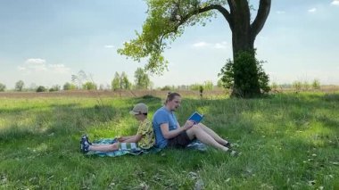 Küçük baba ve oğlu yaz pikniğinin tadını çıkarıyor, birlikte güzel vakit geçiriyorlar. Dışarıdaki eğlenceli aktivitelere katılıyorlar, sıcak güneşin altında mutlu anılar yaratıyorlar.