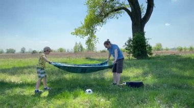 Küçük baba ve oğlu yaz pikniğinin tadını çıkarıyor, birlikte güzel vakit geçiriyorlar. Dışarıdaki eğlenceli aktivitelere katılıyorlar, sıcak güneşin altında mutlu anılar yaratıyorlar.