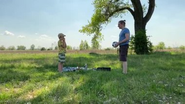 Küçük baba ve oğlu yaz pikniğinin tadını çıkarıyor, birlikte güzel vakit geçiriyorlar. Dışarıdaki eğlenceli aktivitelere katılıyorlar, sıcak güneşin altında mutlu anılar yaratıyorlar.