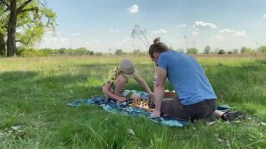 Küçük baba ve oğlu yaz pikniğinin tadını çıkarıyor, birlikte güzel vakit geçiriyorlar. Dışarıdaki eğlenceli aktivitelere katılıyorlar, sıcak güneşin altında mutlu anılar yaratıyorlar.