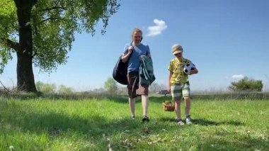 Küçük baba ve oğlu yaz pikniğinin tadını çıkarıyor, birlikte güzel vakit geçiriyorlar. Dışarıdaki eğlenceli aktivitelere katılıyorlar, sıcak güneşin altında mutlu anılar yaratıyorlar.