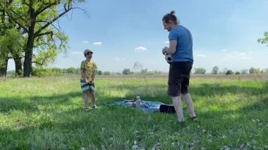 Küçük baba ve oğlu yaz pikniğinin tadını çıkarıyor, birlikte güzel vakit geçiriyorlar. Dışarıdaki eğlenceli aktivitelere katılıyorlar, sıcak güneşin altında mutlu anılar yaratıyorlar.