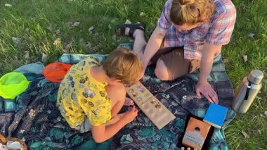 Küçük baba ve oğlu yaz pikniğinin tadını çıkarıyor, birlikte güzel vakit geçiriyorlar. Dışarıdaki eğlenceli aktivitelere katılıyorlar, sıcak güneşin altında mutlu anılar yaratıyorlar.