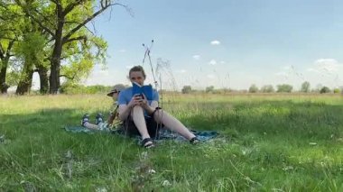 Küçük baba ve oğlu yaz pikniğinin tadını çıkarıyor, birlikte güzel vakit geçiriyorlar. Dışarıdaki eğlenceli aktivitelere katılıyorlar, sıcak güneşin altında mutlu anılar yaratıyorlar.