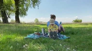 Küçük baba ve oğlu yaz pikniğinin tadını çıkarıyor, birlikte güzel vakit geçiriyorlar. Dışarıdaki eğlenceli aktivitelere katılıyorlar, sıcak güneşin altında mutlu anılar yaratıyorlar.