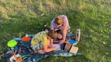 Küçük baba ve oğlu yaz pikniğinin tadını çıkarıyor, birlikte güzel vakit geçiriyorlar. Dışarıdaki eğlenceli aktivitelere katılıyorlar, sıcak güneşin altında mutlu anılar yaratıyorlar.