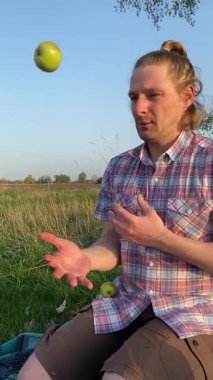 Genç bir baba ve oğlunun yaz pikniğini otlakta birlikte geçirdiği dikey görüntüler. Dışarıdaki eğlenceli aktivitelere katılıyorlar, sıcak güneşin altında mutlu anılar yaratıyorlar.