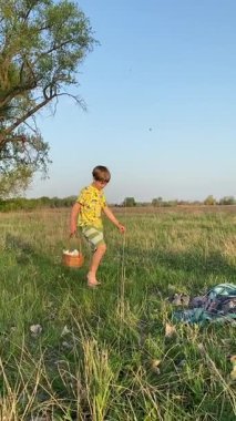 Genç bir baba ve oğlunun yaz pikniğini otlakta birlikte geçirdiği dikey görüntüler. Dışarıdaki eğlenceli aktivitelere katılıyorlar, sıcak güneşin altında mutlu anılar yaratıyorlar.