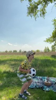 Genç bir baba ve oğlunun yaz pikniğini otlakta birlikte geçirdiği dikey görüntüler. Dışarıdaki eğlenceli aktivitelere katılıyorlar, sıcak güneşin altında mutlu anılar yaratıyorlar.