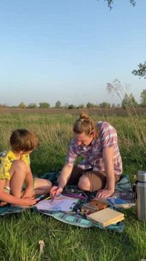 Genç bir baba ve oğlunun yaz pikniğini otlakta birlikte geçirdiği dikey görüntüler. Dışarıdaki eğlenceli aktivitelere katılıyorlar, sıcak güneşin altında mutlu anılar yaratıyorlar.