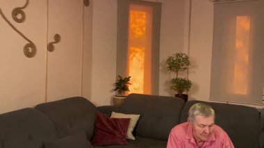 Oturma odasında vergileri, elektrik faturalarını akıllı telefon ve abaküs kullanarak hesap yapan yaşlı bir kadın. Odaklanmış ve düşünceli. Ekonomisini hem modern hem de geleneksel araçlarla yönetiyor. 