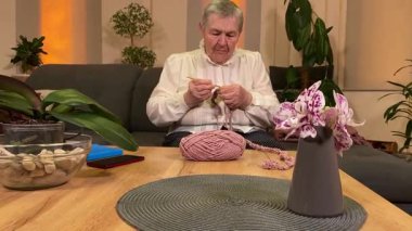 Yaşlı bir kadın evde boş vakit geçirmekten zevk alıyor, rahat bir oturma odasında rahatlatıcı bir hobi ediniyor. Etrafı konforla çevriliyken günlük rutininde ve en sevdiği meşgalesinde neşe ve huzur bulur. 