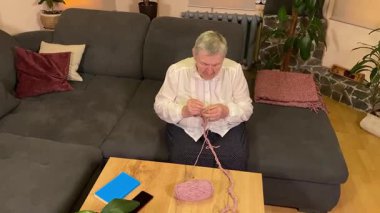 Yaşlı bir kadın evde boş vakit geçirmekten zevk alıyor, rahat bir oturma odasında rahatlatıcı bir hobi ediniyor. Etrafı konforla çevriliyken günlük rutininde ve en sevdiği meşgalesinde neşe ve huzur bulur. 