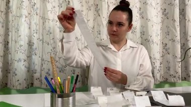 İş elbiseli genç bir kadın ev ofisinde çalışıyor, dizüstü bilgisayar ve telefon kullanıyor. Odaklanmış ve profesyonel olarak, günlük rutininde teknoloji ve iletişimi birleştirerek görevleri etkili bir şekilde yönetiyor. 