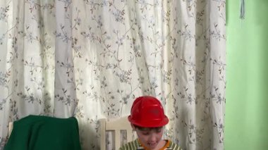 İlkokul çağındaki neşeli genç bir çocuk kapalı bir masada otururken oyuncaklarla oynuyor. Enerji ve hayal gücüyle dolu, rahat, güvenli ve yaratıcı bir ortamda eğleniyor.. 