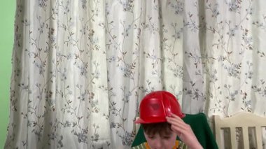 İlkokul çağındaki neşeli genç bir çocuk kapalı bir masada otururken oyuncaklarla oynuyor. Enerji ve hayal gücüyle dolu, rahat, güvenli ve yaratıcı bir ortamda eğleniyor.. 