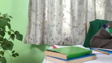 Genç kız evde yaratıcı aktiviteler yapıyor, hobisinin bir parçası olarak kalemlerle resim çiziyor. Odaklanmış ve ilham almış, sanatsal ifadenin günümüze getirdiği eğlence ve rahatlıktan zevk alıyor.. 