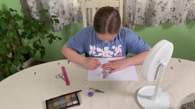 Genç kız makyaj yapmayı evde öğreniyor, kozmetik ürünlerini merakla ve özenle kullanıyor. Genç yaşta güzelliği ve kendine bakımı keşfetti, rahat ve tanıdık bir ortamda pratik yapıyor.. 