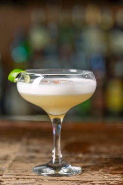 Barda Pisco Sour kokteyli var. Arka plan bulanık. Peru, Meksika, Şili geleneksel likörü limon ve yumurtalı ekşi likör..