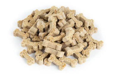 Beyaz arka planda izole edilmiş bir yığın içinde kurumuş köpek maması. Tam alan derinliği.