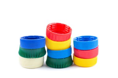 Farklı renk şişe kapakları, geri dönüşüm için mükemmel hammadde. Beyaz üzerine izole edilmiş plastik şişe ve kapaklı kompozisyon.