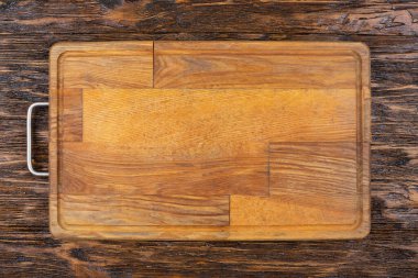 Ahşap bir arka planda boş eski bir kesme tahtası. Tarifin taslağı. Üst görünüm.