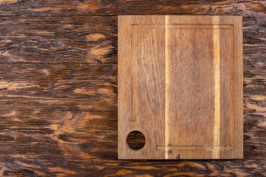 Ahşap bir arka planda boş eski bir kesme tahtası. Tarifin taslağı. Üst görünüm.