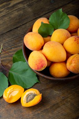 Delicious ripe apricots in a clay bowl on the table close-up. Delicious fruits.