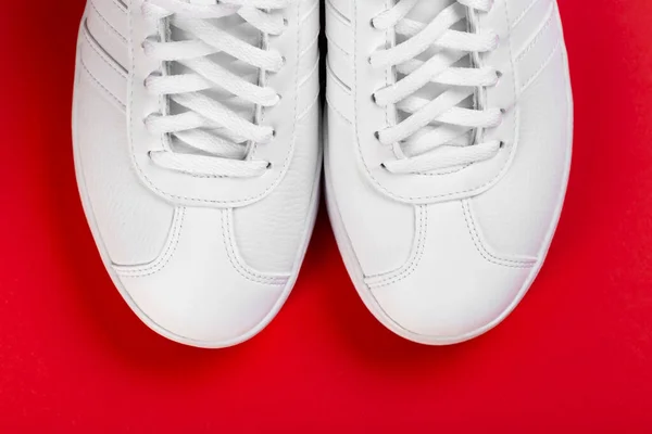 Sport shoes. Pair of White sneaker on red background. Top view.