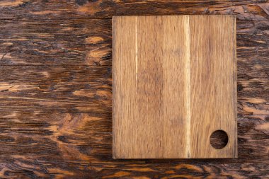 Ahşap bir arka planda boş eski bir kesme tahtası. Tarifin taslağı. Üst görünüm.