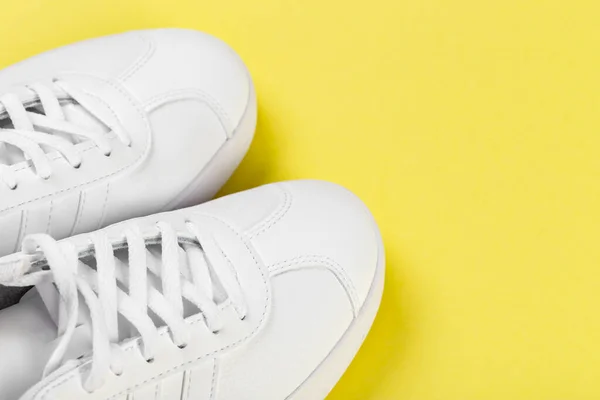 Sport shoes. Pair of White sneaker on yellow background. Top view.