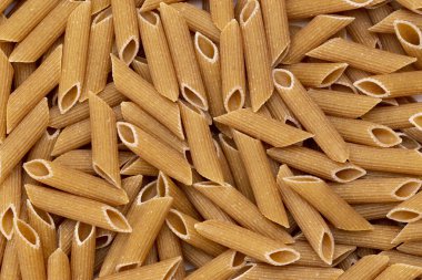 Background from pasta. Penne, Penne Rigate. Top view, close-up.