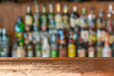 Boş ahşap tezgah, çözülmüş arka plan ve restoran, bar ya da kafeterya şişeleri. Ürün gösteriniz için..