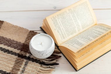 Kitap mumu ve ahşap bir masada ekoseli güzel bir kompozisyon. Zen ve rahatlama konsepti. Konforlu ev dekorasyonu.