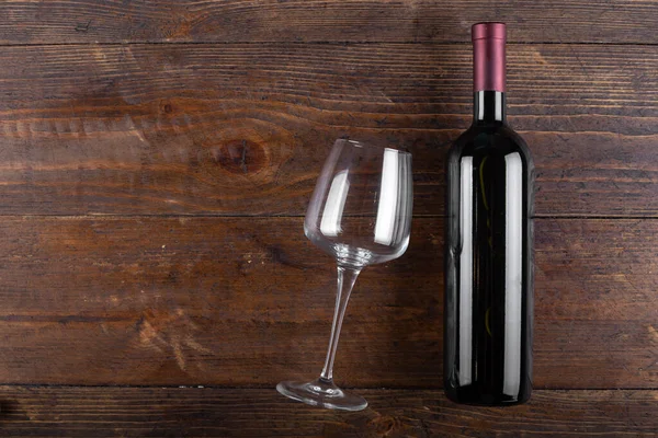 stock image Glass and bottle of red wine on a wooden background. Top view with copy space