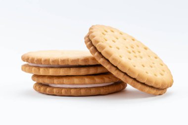 Pembe kremalı sandviç bisküvileri. Sandviç kurabiyeleri beyaz arka planda üst üste durur..