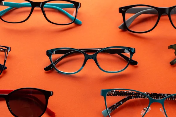 一套眼镜 用于橙色背景上的视觉 光学存储 眼镜选择 眼科测试 眼科检查 时尚配件概念 — 图库照片