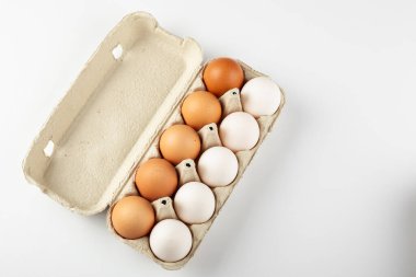 Raw chicken eggs in an egg tray on a white background. Space for text.