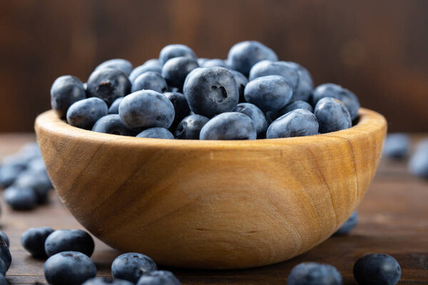 Свежая черника в деревянной чаше. Концепция здорового и диетического питания. Вид сбоку.