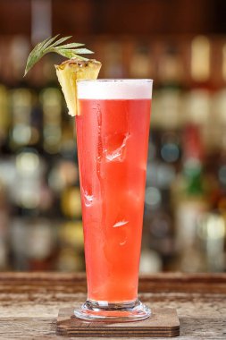 Singapur sling kokteyli cin, kiraz ve portakal likörü Benedict, nar suyu, ananas ve limon suyu acı Angostura ilavesi ile. Kokteyl bar gece kulübünde arka plan üzerinde