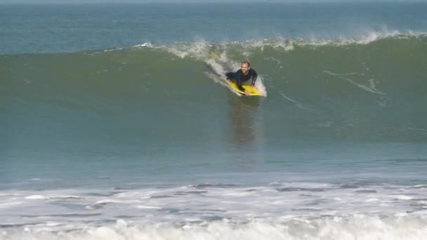 波の上でボディボードでサーフィン男のスローモーションビデオ — ストック動画