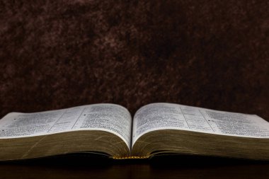 Parlak ahşap bir rafta duran Hristiyan İncili 'ni aç.