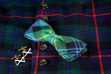 İskoç yelekli İskoç kumaşı, İskoç bayrağı kol düğmeleri ve tartan papyonlu.