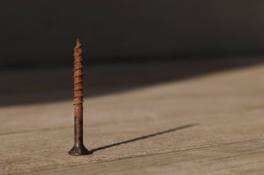 Tahta masadaki paslı çivinin makro görüntüsü.