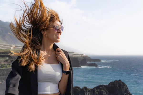 Smiling Woman Puts Jacket Hair Blown Wind Some Cliffs Front — Stock Photo, Image