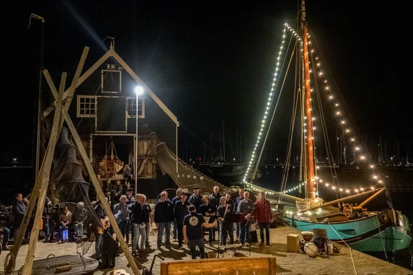 stock image Enkhuizen, Netherlands. October 2022. An old flatboat and a shanty choir in Enkhuizen harbor. Evening shot. High quality photo