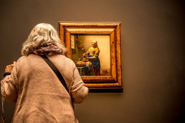 Amsterdam, Hollanda. Aralık 2022. Ziyaretçiler Rijksmuseum 'daki Vermeer' in Sütçü Kızı 'na hayran. Yüksek kalite fotoğraf